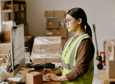 personne administrative devant ordinateur entrepot logistique